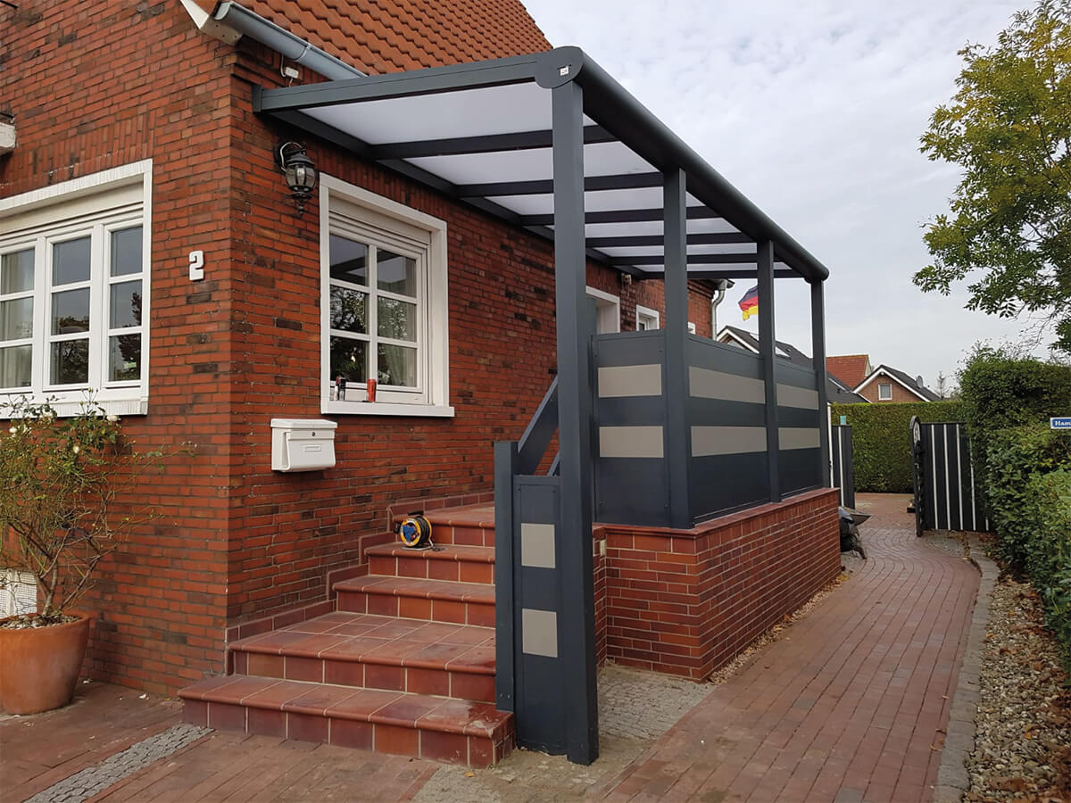 Terrassenüberdachung 3 Überdachter Eingangsbereich mit Treppenaufgang und Zaunelementen und Handlauf