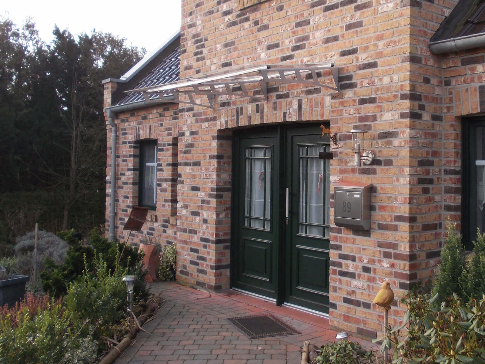 Filigranes Aluminium-Vordach über dem Hauseingang mit Glasabdeckung