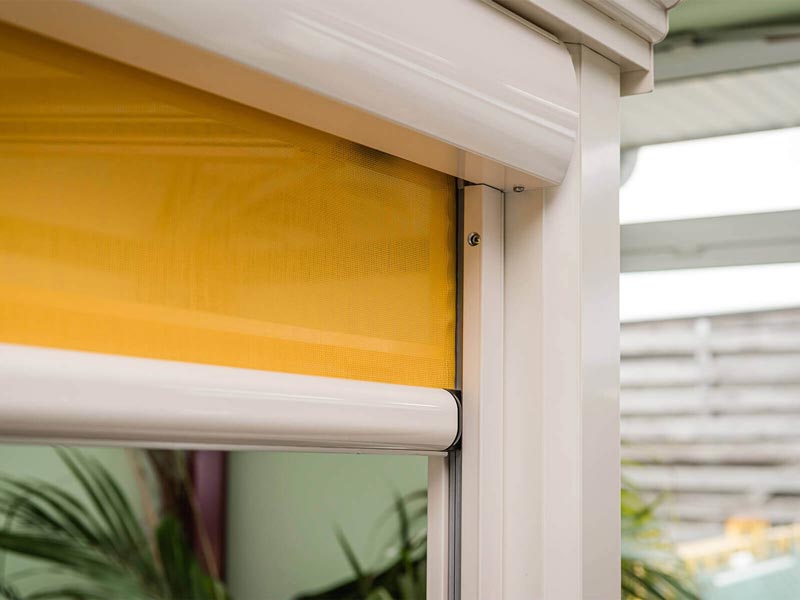 Detailansicht einer Markise mit gelbem Tuch in Aluminiumkassette