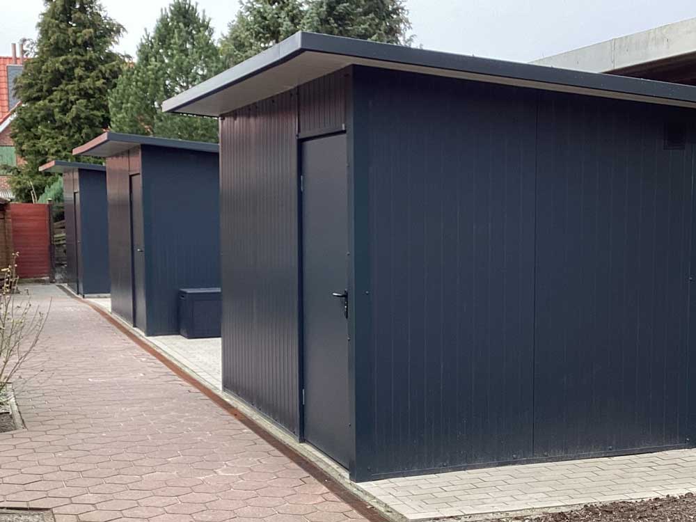 Reihenanlage aus modernen Aluminium-Geräteräumen in Anthrazit mit Flachdach, wetterfeste und langlebige Außenlösung von Roxx Terrassen