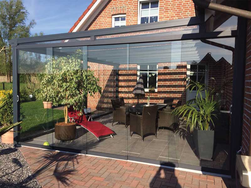 Sommergarten 16 Angebaute Aluminium-Terrassenüberdachung mit bodentiefen Glasschiebewänden, lichtdurchfluteter Wind- und Wetterschutz für den Gartenbereich