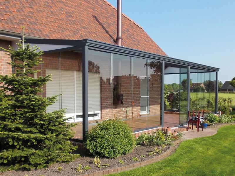 Sommergarten 18 Angebaute Aluminium-Terrassenüberdachung mit bodentiefen Glasschiebewänden, transparenter Wetterschutz und offene Wohnraumerweiterung
