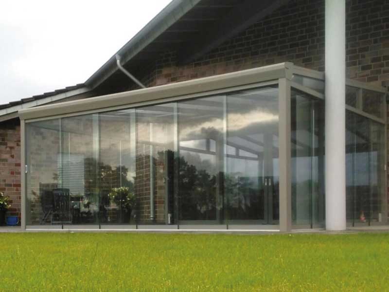 Sommergarten 19 Großflächiger Wintergarten aus Aluminium mit durchgehenden Glasschiebewänden