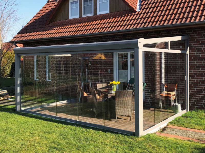 Sommergarten 20 Geschlossene Terrassenüberdachung aus Aluminium mit großflächigen Glasschiebewänden, transparenter Wind- und Wetterschutz für den Garten