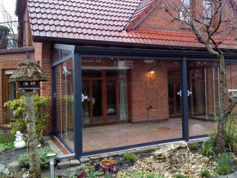 Sommergarten 23 Angebauter Wintergarten aus Aluminium mit Glasdach und großflächigen Glasschiebetüren